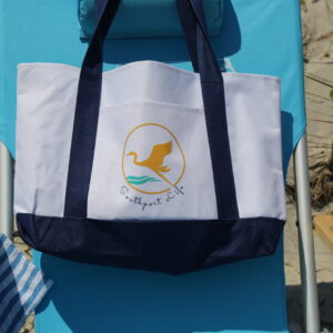 A beach chair with an embroidered bag on it.